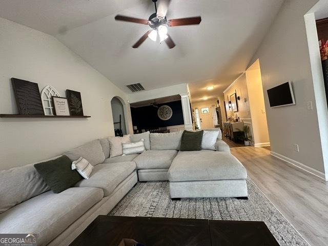 298 Timberwind Dr, Byron, GA 31008 - living room featuring a ceiling fan, light wood-style floors, arched walkways, baseboards, and lofted ceiling