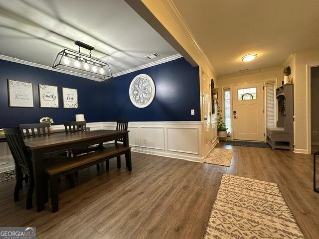 298 Timberwind Dr, Byron, GA 31008 - dining area featuring crown molding, wood finished floors, a decorative wall, and a wainscoted wall