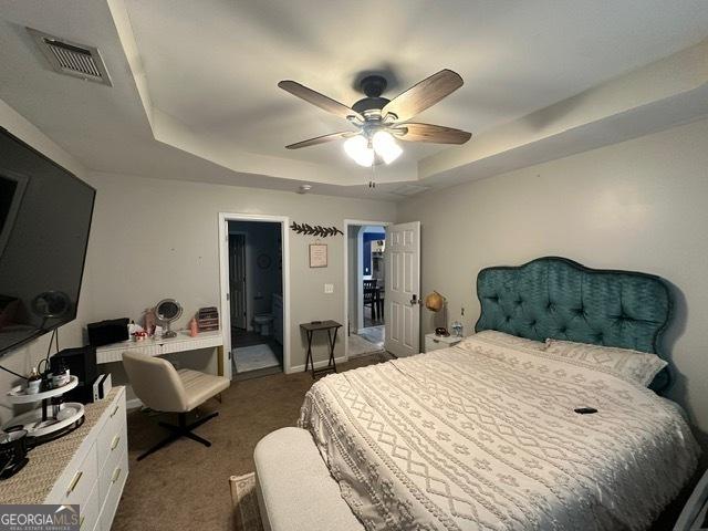 298 Timberwind Dr, Byron, GA 31008 - bedroom featuring a raised ceiling, dark carpet, a ceiling fan, and ensuite bath
