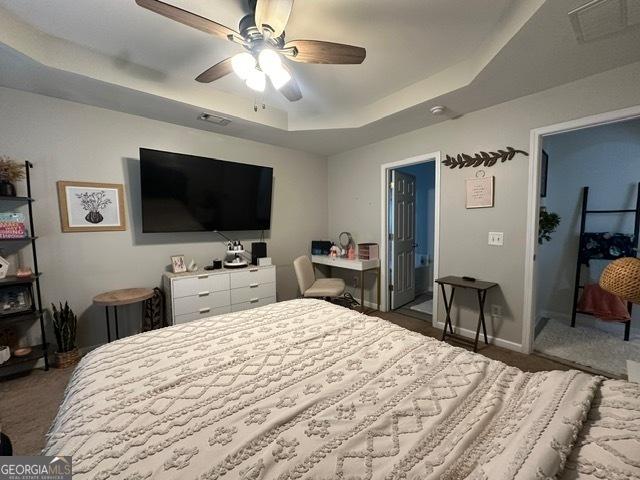 298 Timberwind Dr, Byron, GA 31008 - bedroom with a raised ceiling, dark colored carpet, a ceiling fan, and baseboards