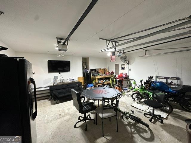 298 Timberwind Dr, Byron, GA 31008 - garage featuring freestanding refrigerator, a garage door opener, and electric panel