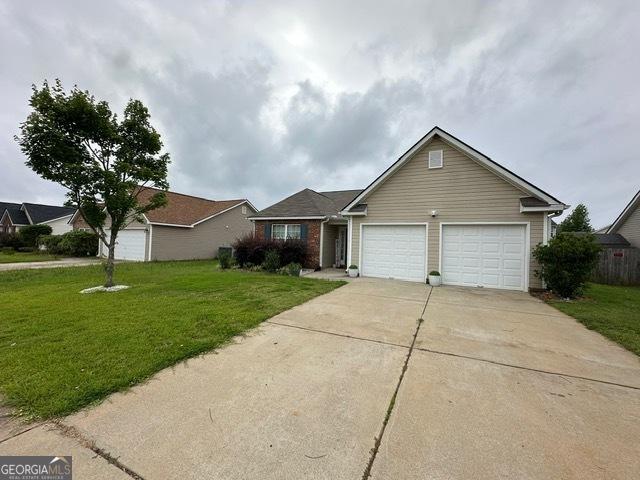 298 Timberwind Dr, Byron, GA 31008 - view of front of house with a garage, driveway, and a front lawn