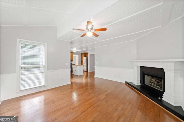 308 Golden Ct, Canton, GA 30114 - unfurnished living room featuring a ceiling fan, a wainscoted wall, light wood-style flooring, and a fireplace with raised hearth