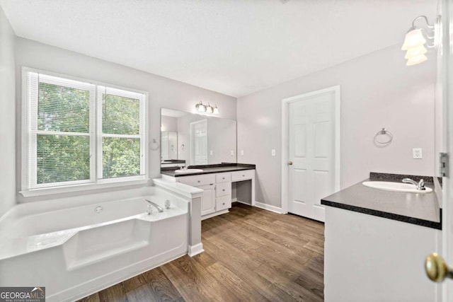 308 Golden Ct, Canton, GA 30114 - bathroom with wood finished floors, a garden tub, two vanities, and baseboards