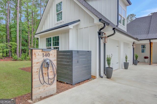 140 S Alexander Creek Rd, Newnan, GA 30263 - view of side of home featuring board and batten siding, a shingled roof, driveway, an attached garage, and a lawn