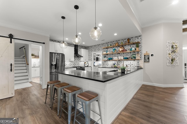 25 Wicklow Ct, Hoschton, GA 30548 - kitchen featuring stainless steel fridge with ice dispenser, wall chimney range hood, dark countertops, a peninsula, and crown molding