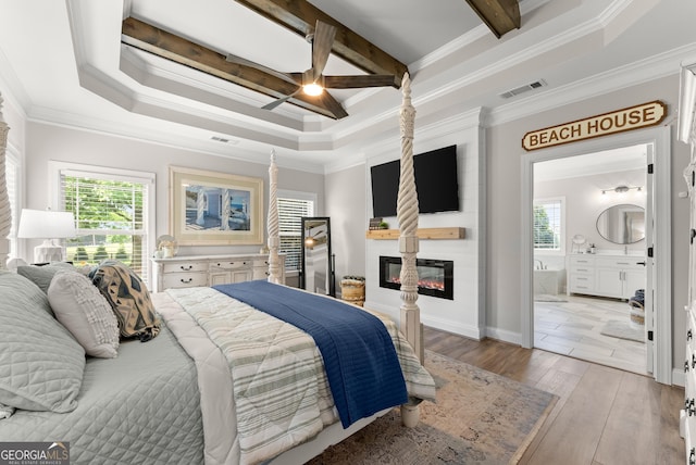 25 Wicklow Ct, Hoschton, GA 30548 - bedroom with a large fireplace, crown molding, light wood-style floors, beamed ceiling, and connected bathroom