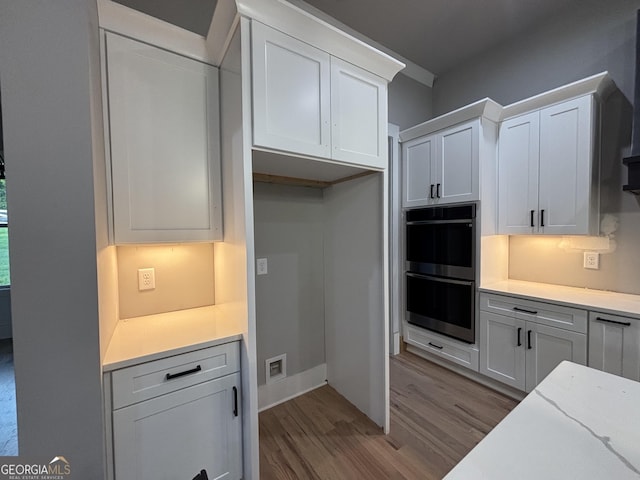 5680 Mack Way, Gainesville, GA 30506 - kitchen featuring stainless steel double oven, wood finished floors, white cabinets, and light stone countertops
