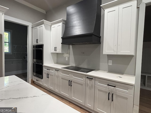5680 Mack Way, Gainesville, GA 30506 - kitchen featuring wall chimney exhaust hood, double oven, black electric cooktop, and light wood-style floors