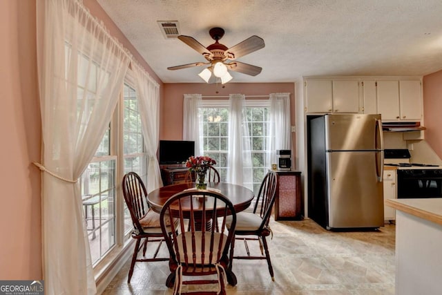1818 Mcconnell Rd, Grayson, GA 30017 - dining area featuring healthy amount of natural light, ceiling fan, light stone finish flooring, and a textured ceiling