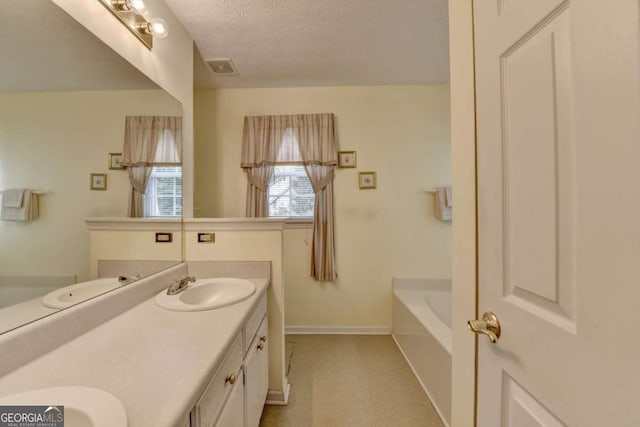 1818 Mcconnell Rd, Grayson, GA 30017 - full bath with double vanity, a bath, a textured ceiling, and baseboards