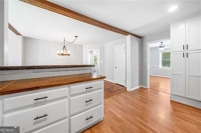 3274 Ridgecrest Rd SE, Smyrna, GA 30080 - kitchen with wooden counters, plenty of natural light, light wood-style floors, white cabinetry, and beamed ceiling
