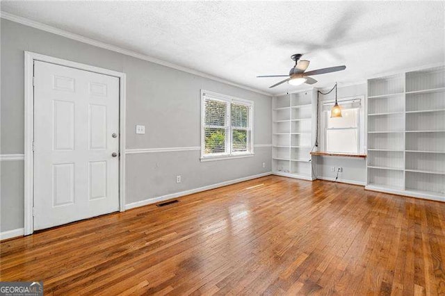 3274 Ridgecrest Rd SE, Smyrna, GA 30080 - unfurnished living room with a ceiling fan, hardwood / wood-style floors, crown molding, a textured ceiling, and baseboards