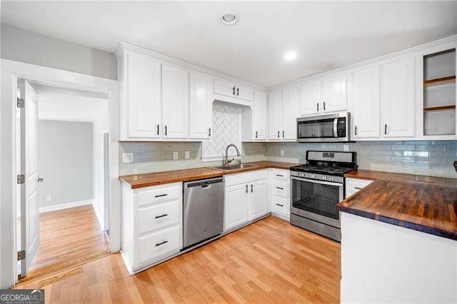 3274 Ridgecrest Rd SE, Smyrna, GA 30080 - kitchen with stainless steel appliances, butcher block counters, a sink, light wood-style floors, and recessed lighting