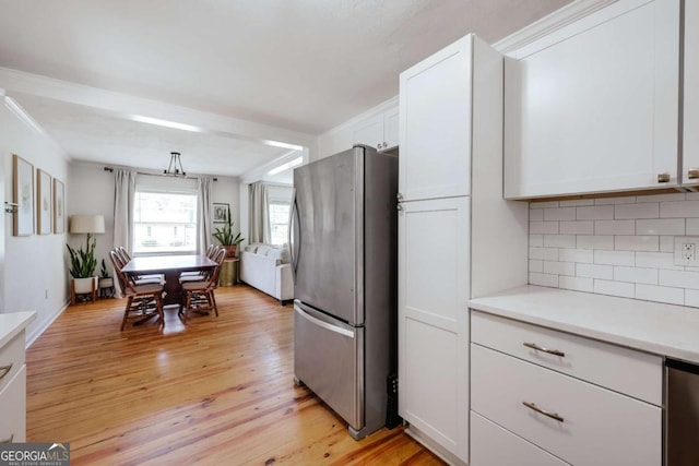 980 Oglethorpe Ave, Athens, GA 30606 - kitchen featuring freestanding refrigerator, white cabinets, decorative backsplash, light countertops, and light wood finished floors