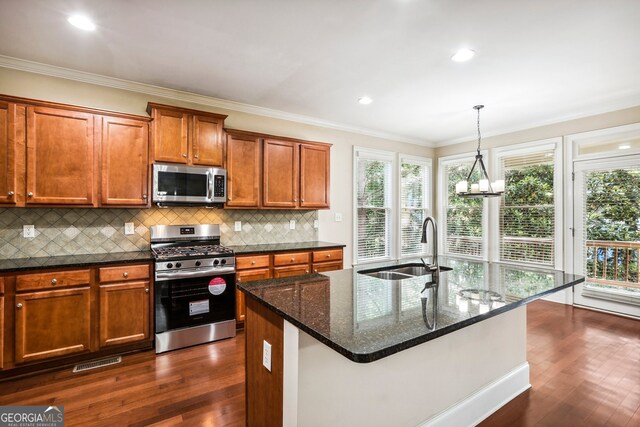 189 Privet Cir, Suwanee, GA 30024 - kitchen with appliances with stainless steel finishes, dark wood finished floors, healthy amount of natural light, brown cabinetry, and ornamental molding