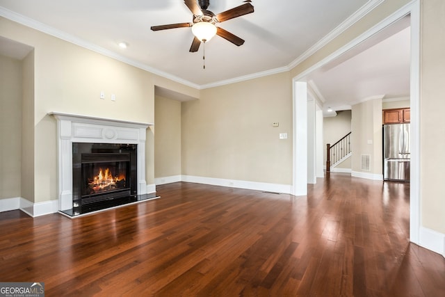 189 Privet Cir, Suwanee, GA 30024 - unfurnished living room featuring dark wood-style flooring, a ceiling fan, a glass covered fireplace, ornamental molding, and stairway