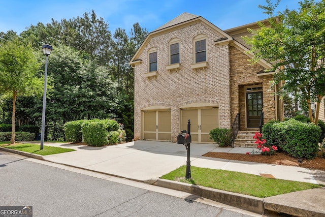 189 Privet Cir, Suwanee, GA 30024 - view of front of house featuring concrete driveway, a garage, brick siding, and stone siding