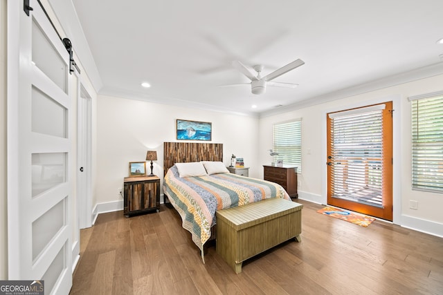 308 Reed St, Scottdale, GA 30079 - bedroom featuring a barn door, ornamental molding, access to outside, wood finished floors, and multiple windows