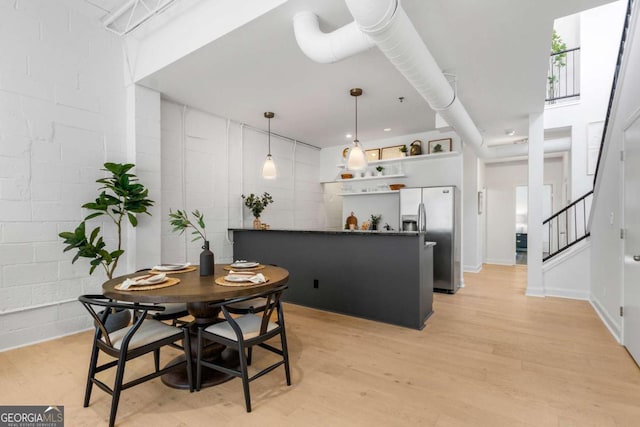 820 Dekalb Ave NE Unit 2, Atlanta, GA 30307 - dining area featuring light wood-style flooring, concrete block wall, and stairs