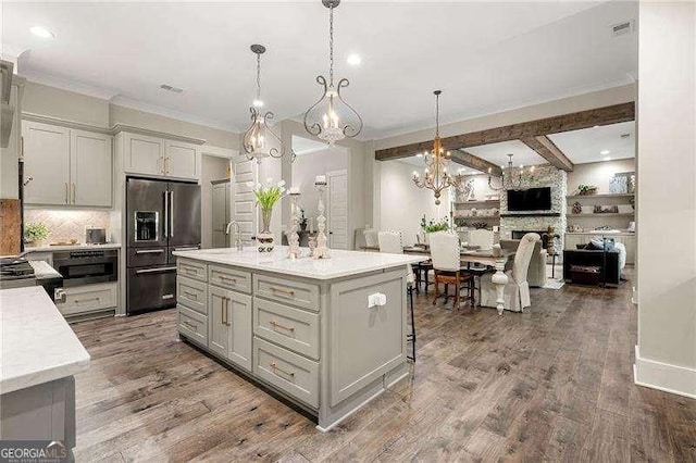 131 Forsyth Park Ln, Woodstock, GA 30188 - kitchen with high quality fridge, a chandelier, crown molding, decorative backsplash, and open floor plan