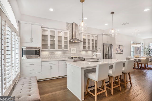 4202 Deming Cir, Sandy Springs, GA 30342 - kitchen with appliances with stainless steel finishes, wall chimney exhaust hood, a kitchen island with sink, dark wood-type flooring, and decorative backsplash