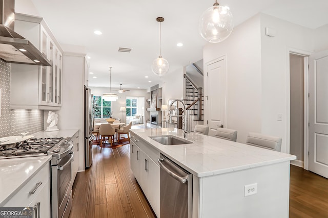 4202 Deming Cir, Sandy Springs, GA 30342 - kitchen featuring stainless steel appliances, wall chimney range hood, dark wood-style flooring, open floor plan, and ceiling fan