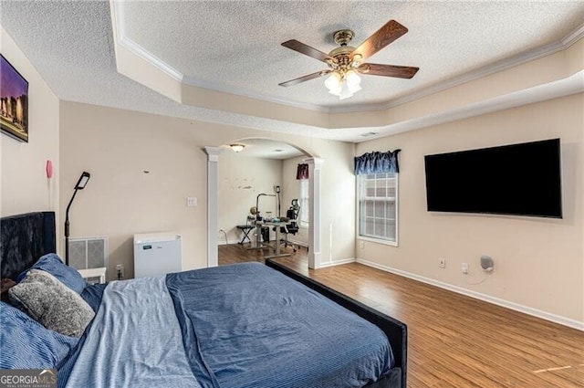 115 Pinnacle Ln, Mcdonough, GA 30253 - bedroom with crown molding, a textured ceiling, arched walkways, wood finished floors, and decorative columns