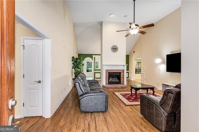 115 Pinnacle Ln, Mcdonough, GA 30253 - living area with high vaulted ceiling, wood finished floors, ceiling fan, a brick fireplace, and baseboards