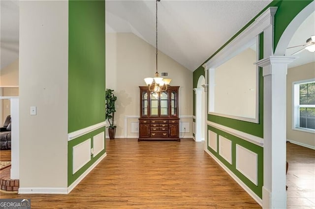 115 Pinnacle Ln, Mcdonough, GA 30253 - dining room with ornate columns, a chandelier, wood finished floors, and high vaulted ceiling