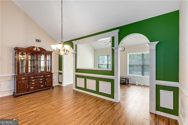 115 Pinnacle Ln, Mcdonough, GA 30253 - unfurnished dining area featuring a chandelier, ornate columns, wood finished floors, and vaulted ceiling