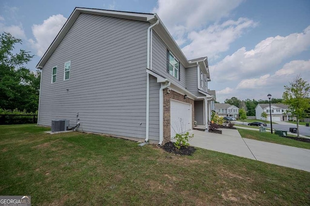 6827 Chataran Dr, Lithia Springs, GA 30122 - view of side of property with concrete driveway, a lawn, an attached garage, and central AC