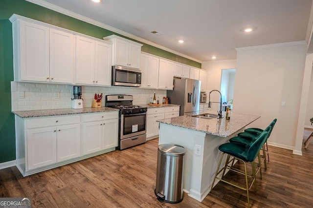 6827 Chataran Dr, Lithia Springs, GA 30122 - kitchen with appliances with stainless steel finishes, a sink, crown molding, a kitchen island with sink, and tasteful backsplash