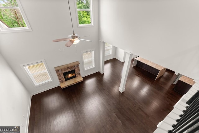 2855 Pilgrim Mill Rd, Cumming, GA 30041 - unfurnished living room with a towering ceiling, a ceiling fan, dark wood-style floors, a fireplace, and baseboards