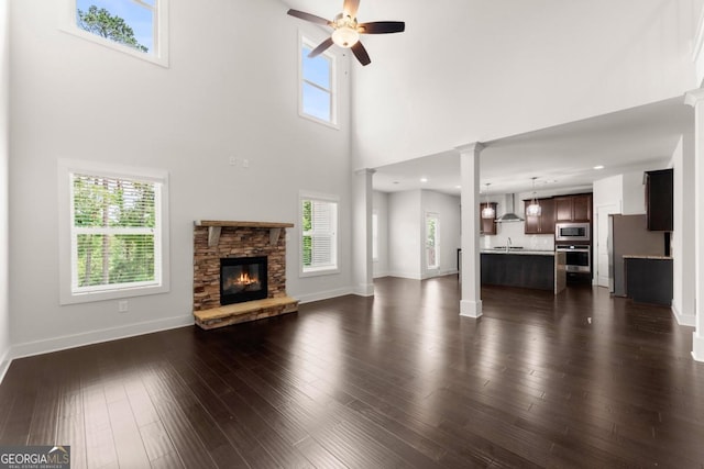 2855 Pilgrim Mill Rd, Cumming, GA 30041 - unfurnished living room with a sink, ceiling fan, baseboards, a fireplace, and a towering ceiling