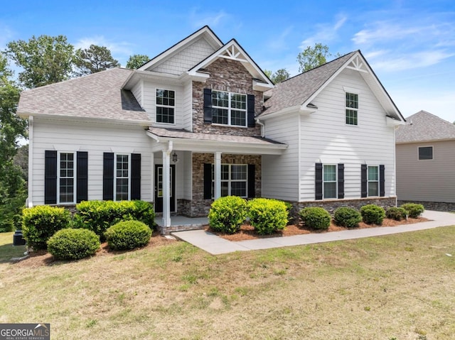 2855 Pilgrim Mill Rd, Cumming, GA 30041 - craftsman-style home with stone siding, a front lawn, a porch, and a shingled roof