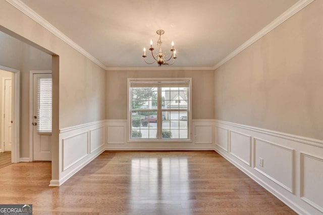 2842 Sedgeview Ln, Buford, GA 30519 - spare room featuring wood finished floors, a chandelier, a wainscoted wall, crown molding, and a decorative wall