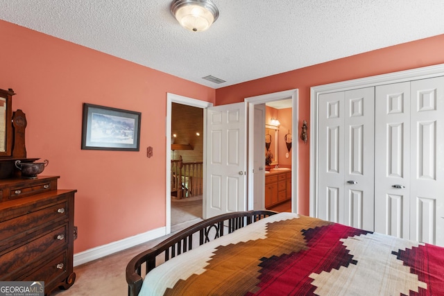 3498 Overland Trl, Ellenwood, GA 30294 - bedroom featuring a closet, light carpet, a textured ceiling, baseboards, and ensuite bath