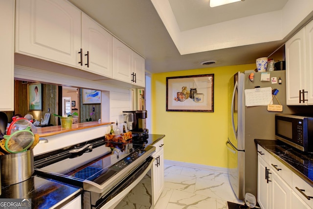 227 Shakespeare Dr # 303, Clayton, GA 30525 - kitchen featuring stainless steel appliances, light marble finish flooring, white cabinetry, dark countertops, and baseboards