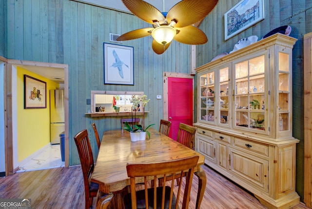 227 Shakespeare Dr # 303, Clayton, GA 30525 - dining area with light wood-style flooring, a ceiling fan, baseboards, and wood walls