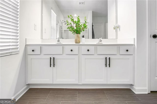 1363 Cooper Springs Rd, Grayson, GA 30017 - bathroom featuring double vanity, baseboards, and wood finish floors
