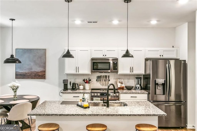 1363 Cooper Springs Rd, Grayson, GA 30017 - kitchen featuring appliances with stainless steel finishes, a sink, decorative backsplash, and white cabinetry