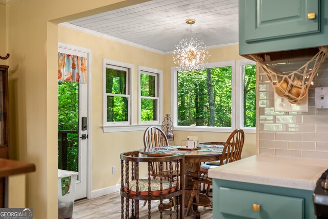 534 Mountainside Dr, Rabun Gap, GA 30568 - dining area with light wood-type flooring, crown molding, a chandelier, and baseboards