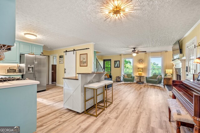534 Mountainside Dr, Rabun Gap, GA 30568 - living area with a textured ceiling, a barn door, light wood finished floors, stairway, and crown molding