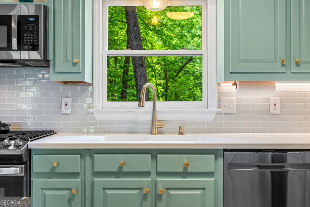 534 Mountainside Dr, Rabun Gap, GA 30568 - kitchen featuring green cabinetry, stainless steel appliances, tasteful backsplash, and a sink