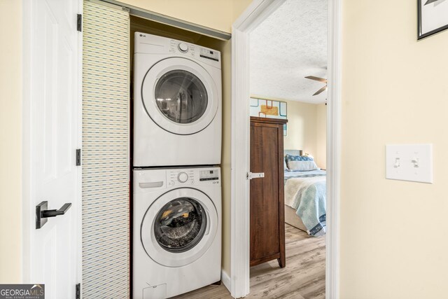 534 Mountainside Dr, Rabun Gap, GA 30568 - laundry area featuring stacked washing machine and dryer, light wood-style flooring, a textured ceiling, and ceiling fan