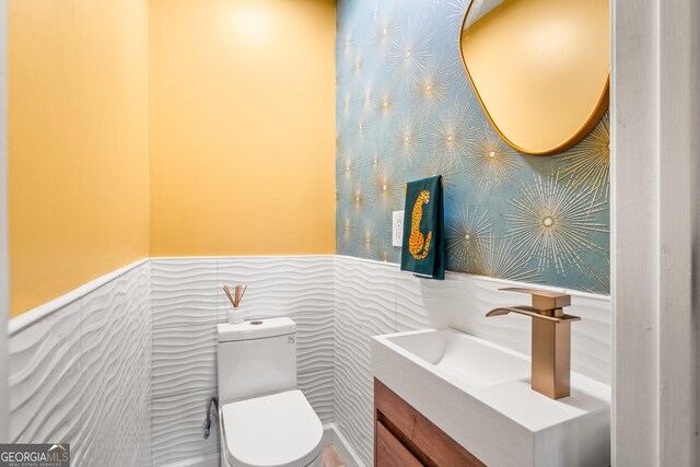 534 Mountainside Dr, Rabun Gap, GA 30568 - bathroom featuring a wainscoted wall, vanity, toilet, and wallpapered walls