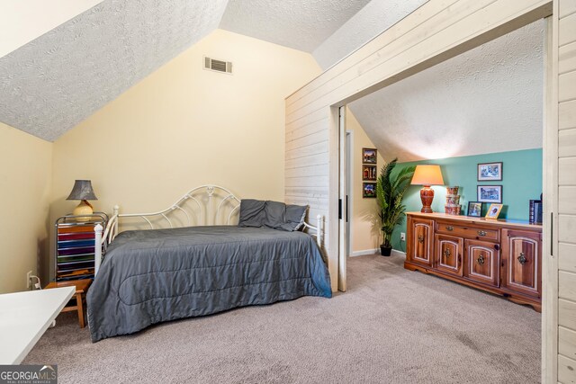 534 Mountainside Dr, Rabun Gap, GA 30568 - bedroom with a textured ceiling, lofted ceiling, and carpet floors
