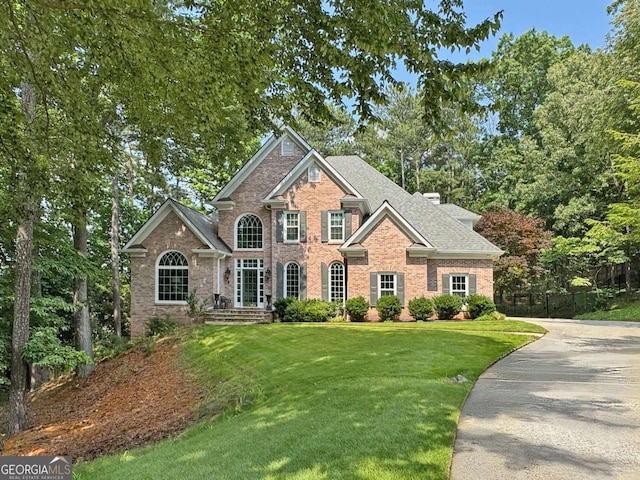 120 Forest Breeze Cv, Alpharetta, GA 30022 - view of front of property featuring brick siding, roof with shingles, view of scattered trees, and driveway