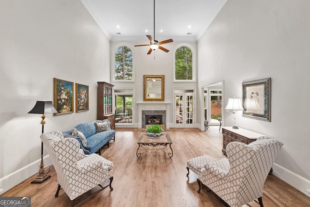 120 Forest Breeze Cv, Alpharetta, GA 30022 - living area featuring plenty of natural light, crown molding, a ceiling fan, a high ceiling, and wood finished floors